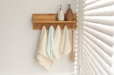 Temiz waffle havluları ve banyoda askıda asılı fırça.