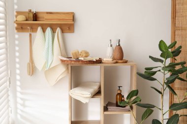 Temiz waffle havluları kancada asılı, fırça ve spa ürünleri banyoda