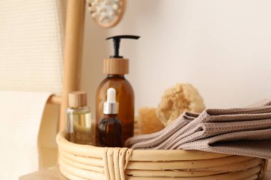 Beyaz duvarın yanında temiz waffle havluları ve spa ürünleri, yakın plan.