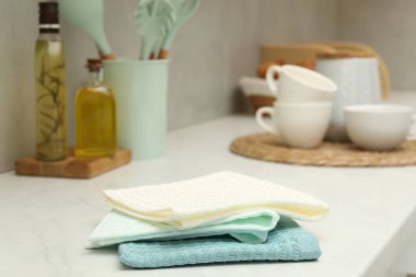 Waffle havluları ve bulaşık takımları beyaz tezgahta, yakın plan.