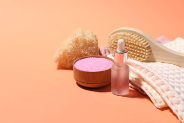 Mercan arka planında temiz waffle havluları ve spa ürünleri, yakın plan.