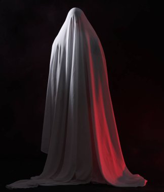 Ürkütücü hayalet. Siyah arka planda beyaz çarşaflı adam