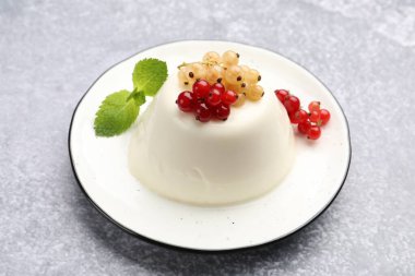 Nefis panna cotta üzümlü ve nane şekerli açık gri masa, yakın plan.