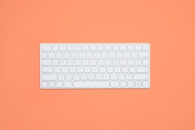 Renk arkaplanı üzerinde modern beyaz kablosuz klavye, üst görünüm