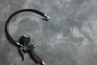 Gri arka planda göstergesi olan bir lastik enflasyon silahı. Metin için boşluk