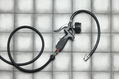 Işıklı arka planda göstergesi olan bir lastik enflasyon silahı, üst görünüm.