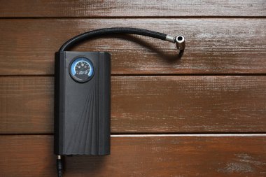 Ahşap arka planda bir lastik şişirme aleti, üst manzara. Metin için boşluk