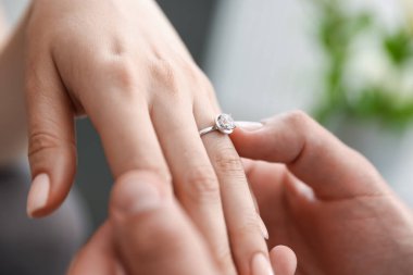 Evlenme teklif ediyorum. Adam içeride kız arkadaşının parmağına nişan yüzüğü takıyor.