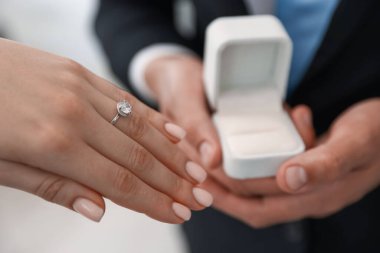 Evlenme teklif ediyorum. Nişan yüzüklü kadın ve nişanlısı içeride, yakın plan.