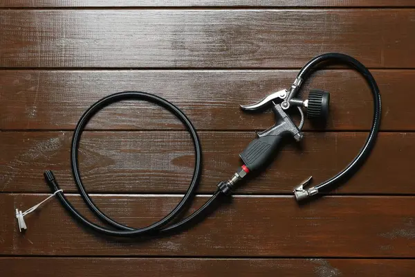 Ahşap arka planda göstergesi olan bir enflasyon tabancası.