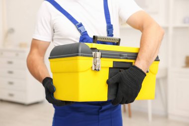 Kapalı mekanda alet çantası olan profesyonel bir tamirci.