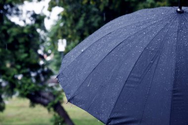 Dışarıda sağanak yağmur altında mavi şemsiye, yakın çekim. Metin için boşluk