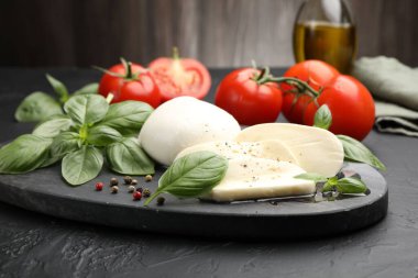 Lezzetli mozzarella peyniri, domates, fesleğen, karabiber ve yağ, yakın plan.