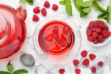 Lezzetli ahududu çayı, böğürtlen ve yapraklar beyaz mermer masada, düz yerde