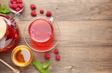 Aromatik ahududu çayı, böğürtlen, nane ve bal, ahşap masa, düz yatak. Metin için boşluk