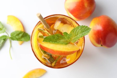 Limonlu buzlu çay, beyaz arka planda şeftali ve nane.