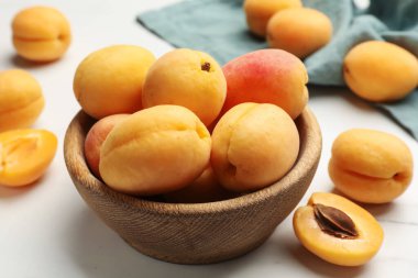 Taze kayısılar kasede beyaz mermer masada, yakın plan.