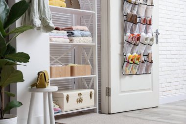 Kapısında farklı ayakkabılar ve içeride giysi olan bir organizatör. Ayakkabı deposu