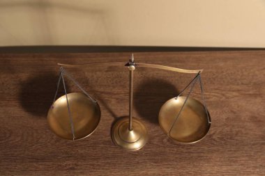 Adaletin terazisi ahşap masada, manzaranın üstünde.