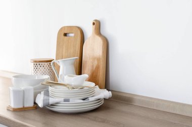 Mutfakta farklı beyaz bulaşık takımları ve kesme tahtaları var.