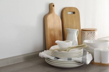 Mutfakta farklı beyaz bulaşık takımları ve kesme tahtaları var.