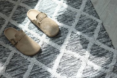 Zeminde şık bej terlikler var, üst tarafta.