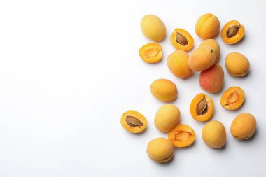 Beyaz arka planda bir sürü taze kayısı, düzlük. Metin için boşluk