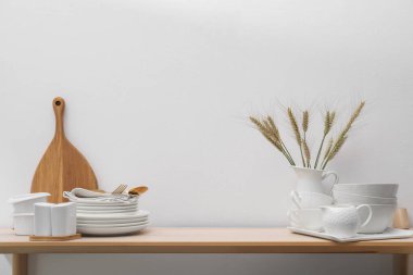 Farklı beyaz bulaşık takımları, tahta kesme tahtaları ve kapalı masa çivileri.