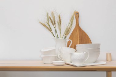 Farklı beyaz bulaşık takımları, tahta kesme tahtaları ve tahta çiviler kapalı masa, yazı için yer