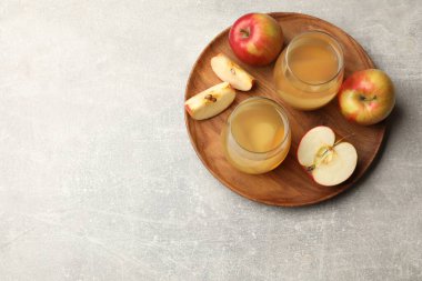 Lezzetli bardaklar ve gri masada taze elmalar, üst manzara. Metin için boşluk