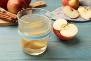 Lezzetli cam karışımı, taze elma ve tarçın açık mavi ahşap masa, yakın plan.