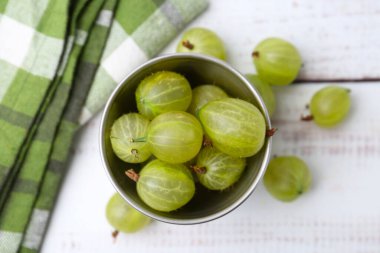 Olgun yeşil bektaşi üzümleri kasede, beyaz ahşap masada, düz yatıyordu.