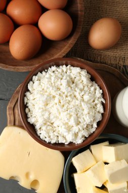 Farklı süt ürünleri ve yumurtalar gri ahşap masa üzerinde, düz yatıyordu.
