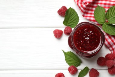 Lezzetli reçel, taze ahududu ve beyaz ahşap masa üzerinde yapraklar, düz uzanma. Metin için boşluk