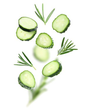 Salatalık dilimleri ve biberiye beyaz arka plana düşüyor