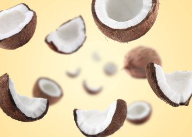 Havada dönen hindistan cevizleri bej arka planda