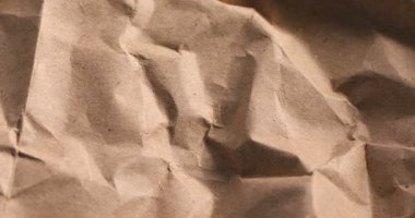 Çevre dostu ambalaj. Arka plan olarak buruşmuş Kraft kağıdı, yakın plan. Kamera yakınlaşıyor ve sola hareket ediyor