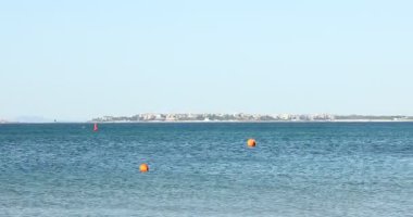 Açık mavi gökyüzünün altında güzel dalgalı deniz, kamera sağa doğru hareket ediyor.