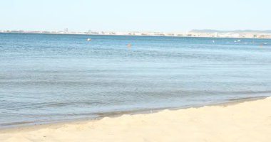 Güzel dalgalı deniz ve kumlu sahil.