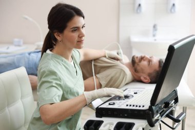 Sonograf klinikte tiroid bezini ultrasona sokuyor.