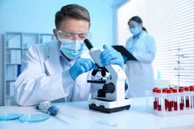 Tıbbi analiz. Laboratuvarda mikroskopla çalışan bilim adamı, seçici odaklanma