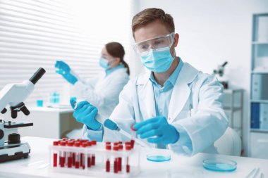 Tıbbi analiz. Laboratuvarda kan örneğiyle çalışan bir bilim adamı.