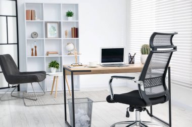 Ahşap masada modern dizüstü bilgisayarı olan şık bir iş yeri.