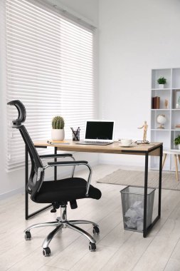 Ahşap masada modern dizüstü bilgisayarı olan şık bir iş yeri.