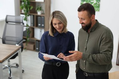 Ofiste birlikte çalışan gülümseyen iş ortakları