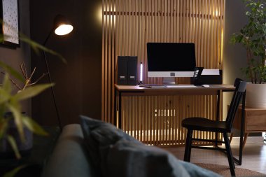 Ahşap masalı, bilgisayarlı ve sandalyeli şık bir iş yeri.