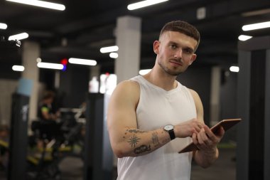 Spor merkezinde tableti olan kişisel antrenör. Metin için boşluk