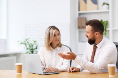 Ofiste dizüstü bilgisayarla çalışan iş ortakları