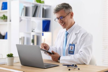 Teletıp. Doktor içeride bilgisayarla hastayla görüntülü konuşma yaparken not alıyor.