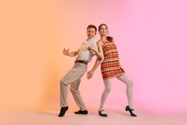 Arka planda dans eden retro kıyafetli mutlu çift.